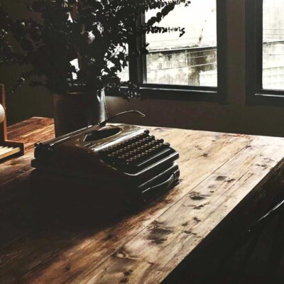 Typewriter on a beautiful wood desk by the window